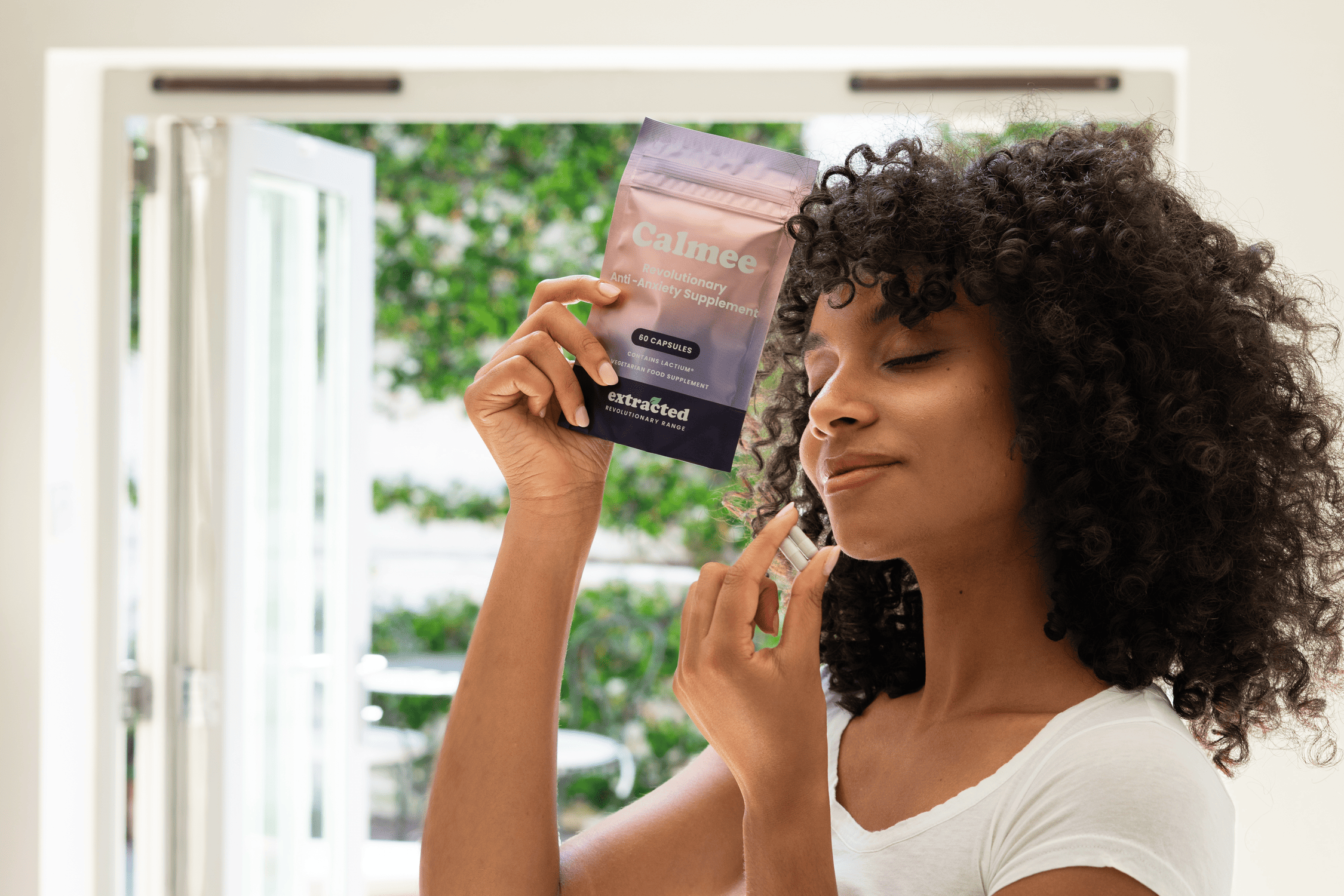 A woman holding supplement capsules