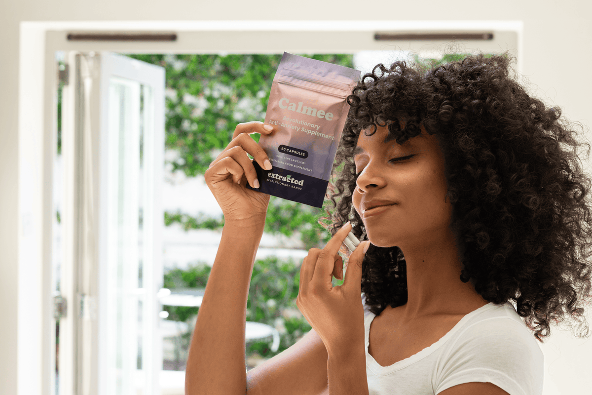 A woman holding supplement capsules