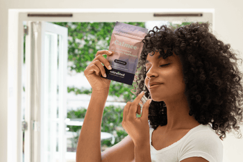A woman holding supplement capsules