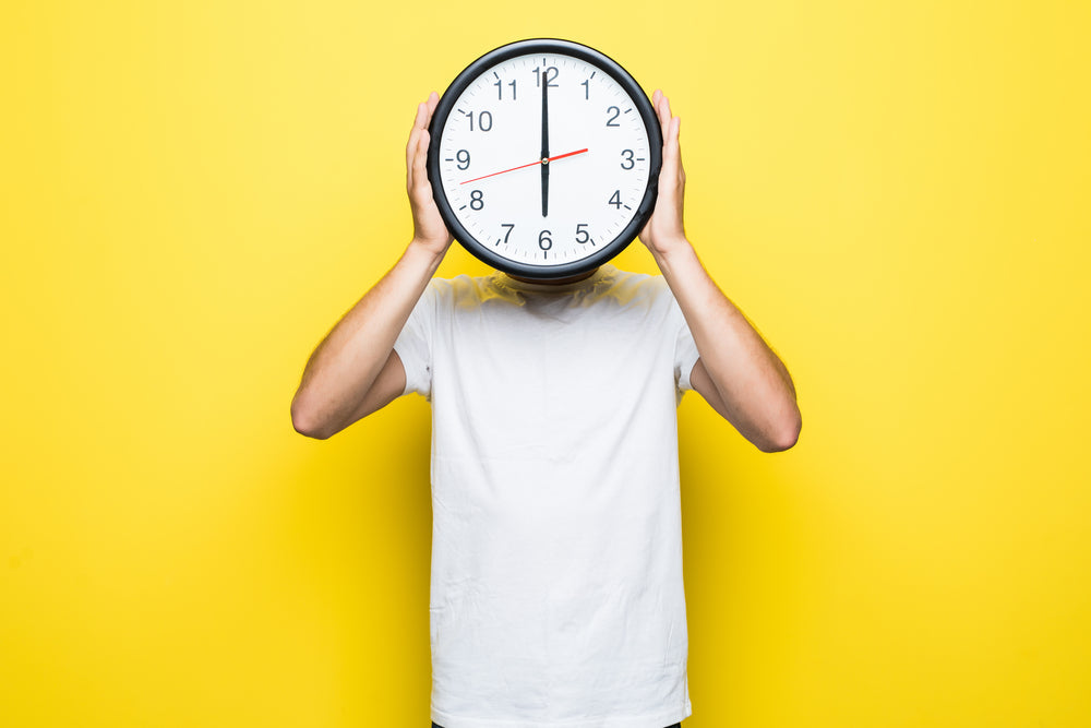 a man with a clock on his head 