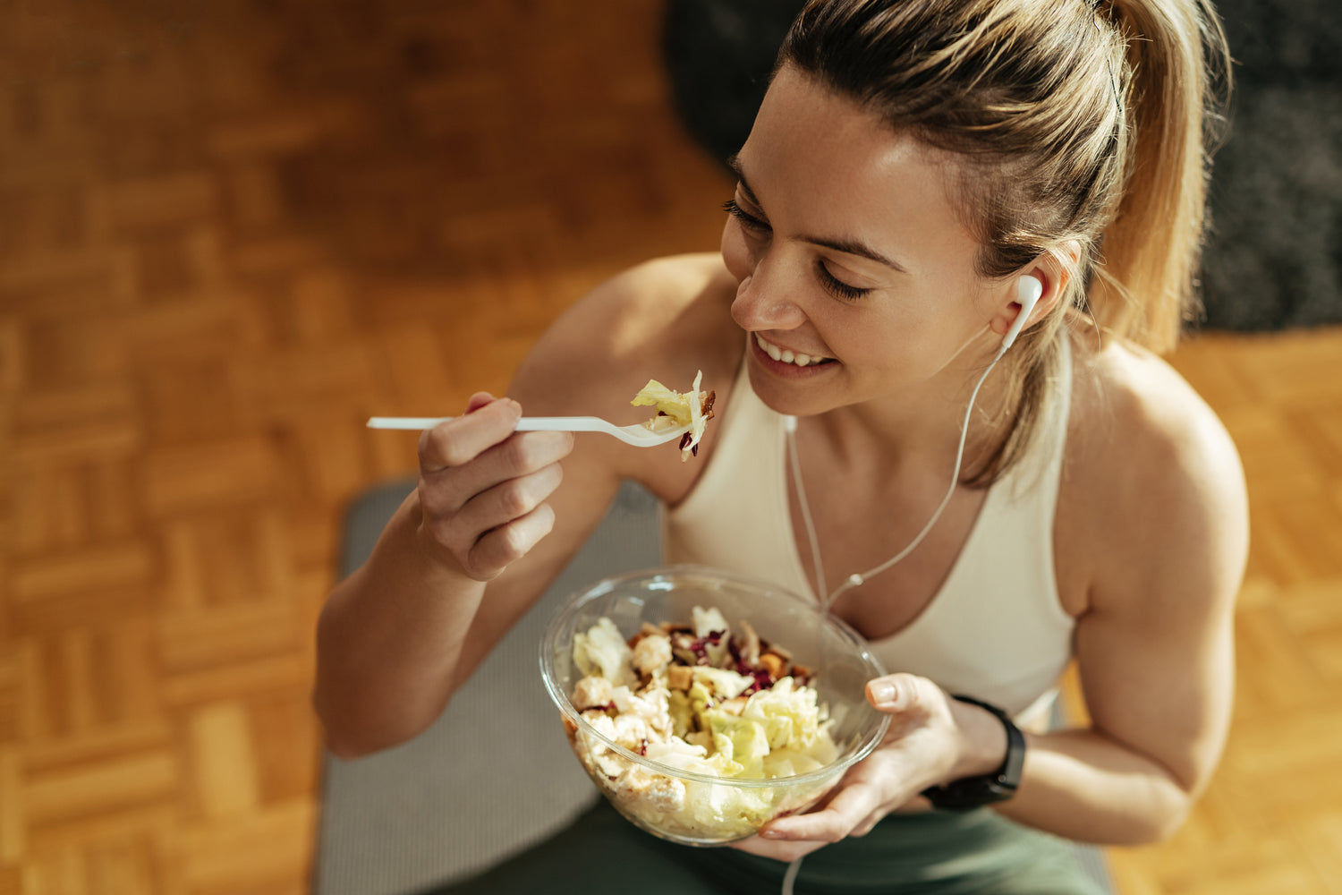 woman eating a salad from a bowl 