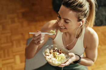 woman eating a salad from a bowl 