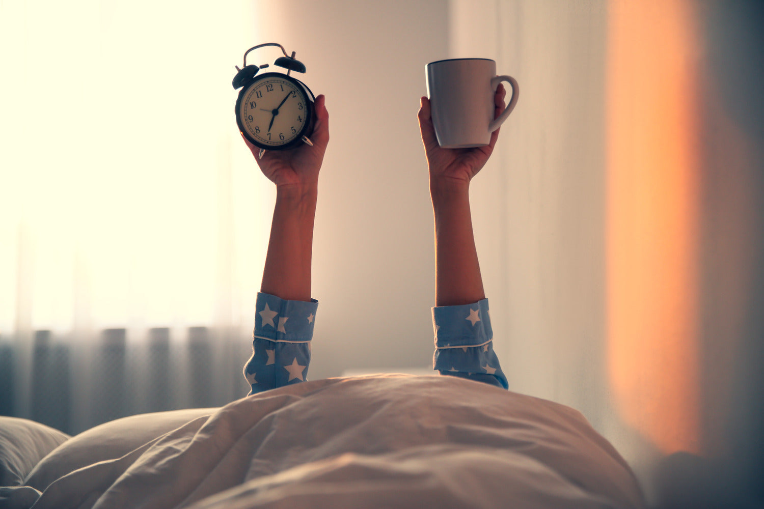 A woman holding up a mug and clock 