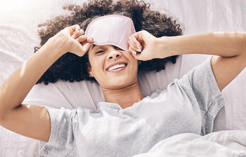 A woman looking under her sleep mask 
